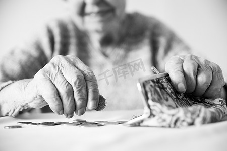 详细的特写照片显示，面目全非的老年妇女在支付账单后，手数着钱包里养老金中剩余的硬币。
