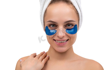 一位美丽的年轻女子洗完澡后的肖像，她的眼睛下面有蓝色的化妆品斑块