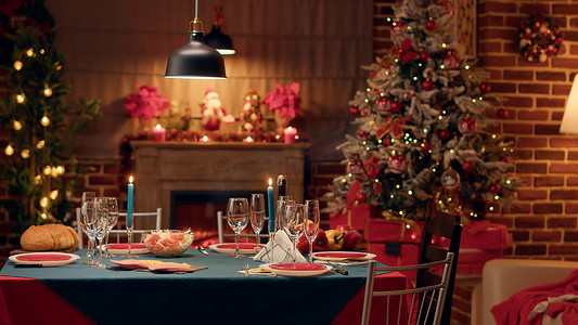 圣诞大餐摄影照片_装饰客厅内空荡荡的传统圣诞餐桌，配有节日花环和餐具