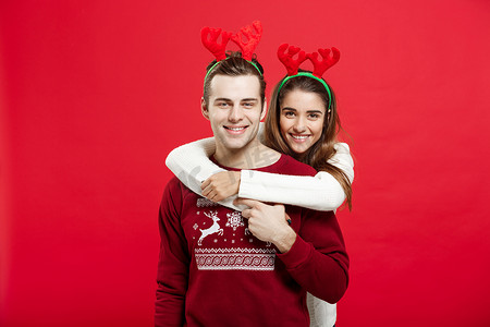 圣诞节概念 — 穿着圣诞毛衣的浪漫情侣互相拥抱