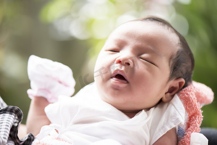 新生婴儿在母亲手中张开嘴，选择性聚焦在她的眼睛里，家庭概念