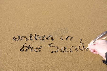 字金色沙子摄影照片_手写在沙子上