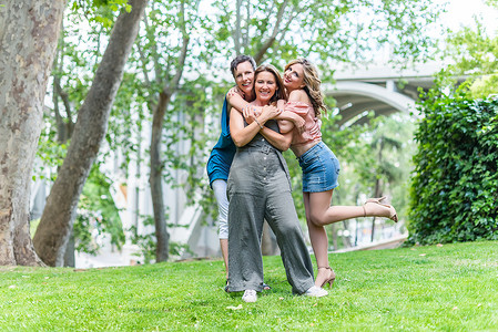 三个快乐的成熟女性朋友站在一起拥抱