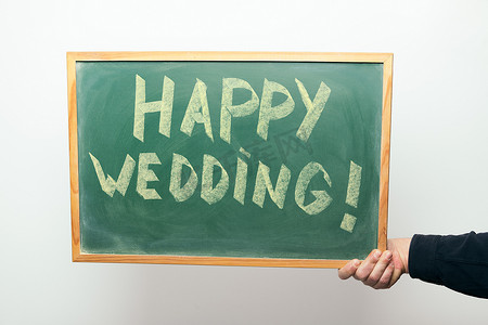 手写快乐摄影照片_黑板上用粉笔手写的“婚礼快乐”