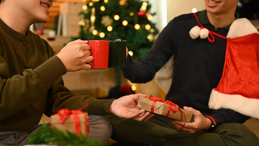 微笑的男人一起庆祝圣诞节或新年，碰杯热巧克力。