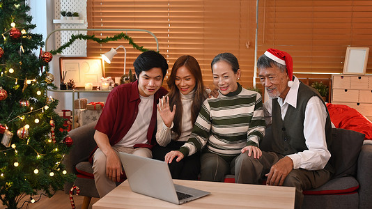 欢庆庆祝摄影照片_幸福的家庭在家里一起庆祝圣诞节的形象，灯光柔和，蜡烛闪烁。