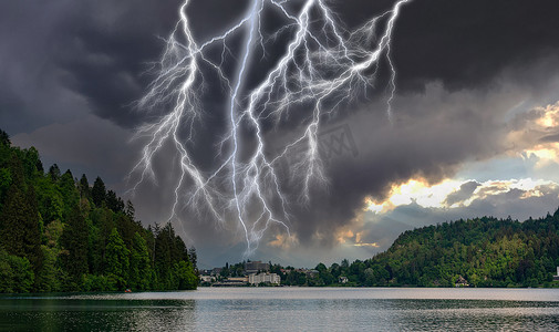 雷电天气摄影照片_湖上城市上空的几道闪电