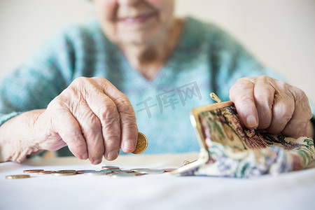 详细的特写照片显示，面目全非的老年妇女在支付账单后，手数着钱包里养老金中剩余的硬币。