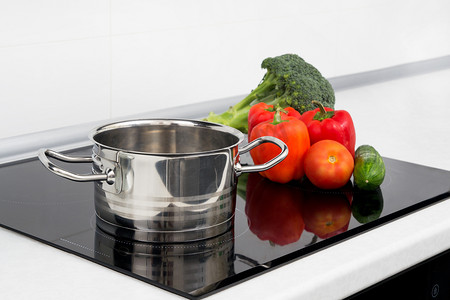 带电磁炉的现代厨房里的锅和蔬菜