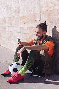 运动员休息摄影照片_足球运动员休息时咨询他的手机