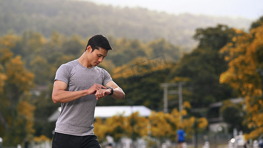 运动员在公园晨练时休息并在智能手表上检查心率数据。