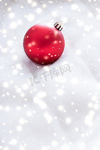 红色小雪花摄影照片_蓬松毛皮上的红色圣诞小玩意，雪花闪闪发光，奢华的冬季假期设计背景