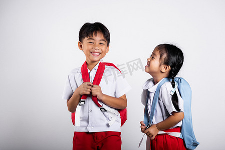 裤子裙子摄影照片_两个亚洲学生孩子女孩男孩学童兄弟姐妹微笑快乐穿着学生泰国制服红色裤子裙子