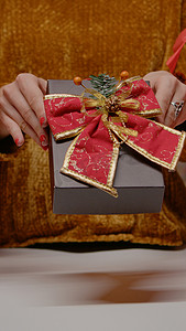 拿着带丝带和领结的礼物盒的手的特写