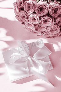 豪华假日丝绸礼盒和玫瑰花束，粉红背景、浪漫惊喜和鲜花作为生日或情人节礼物