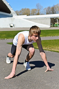 准备跑步的人摄影照片_年轻的运动员准备跑步。