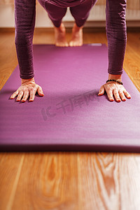 瑜伽垫上练习体式的女人的腿和手