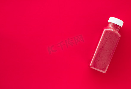 排毒超级食品草莓冰沙瓶，用​​于减肥清洁。红色背景，食品和营养专家博客的平面设计