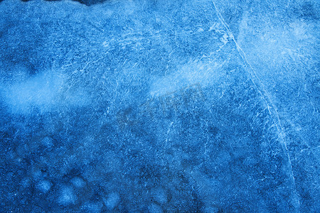 深蓝色蓝色摄影照片_深蓝色破裂的冰冬季表面