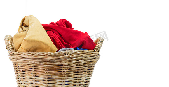 衣柜里的衣物摄影照片_在白色背景隔绝的洗衣柳条篮子里的衣服。