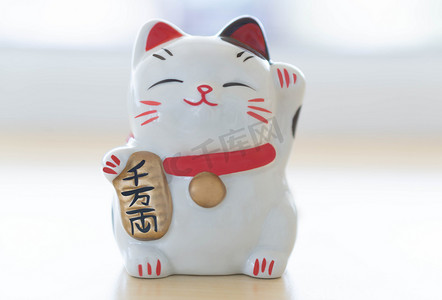 Maneki neko 招财猫在手上显示文字，意思是桌子上富有，s