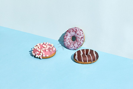 焦糖和巧克力糖衣的三个甜甜甜甜圈，两种颜色的背景