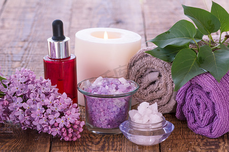 淡紫色花、有芳香油的红色瓶、灼烧的蜡烛、海盐和毛巾