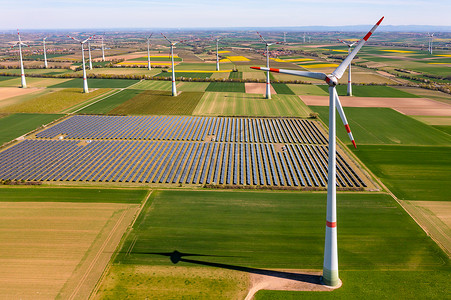 从上面看到的带有风力涡轮机的太阳能公园的太阳能模块，为能源转型提供绿色电力