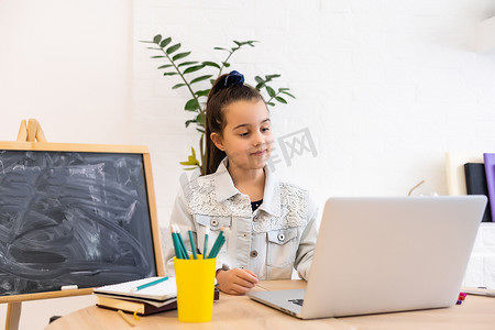 聪明的小女孩在笔记本电脑上在线学习，在家视频聊天，远程教育