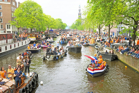 王者出征摄影照片_阿姆斯特丹 — 4 月 26 日：阿姆斯特丹运河上挤满了船只和人
