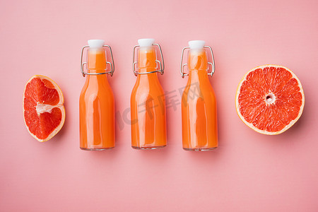 鲜榨葡萄柚汁，粉红色质感的夏季背景，顶视图平躺