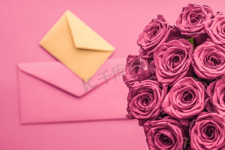 信封书信摄影照片_节日情书和鲜花递送、豪华玫瑰花束和腮红粉红色背景的卡片，适合浪漫的节日设计