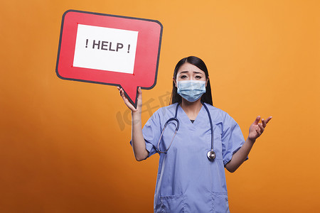 保健诊所护士戴着防护面具拿着纸板语音气泡标志