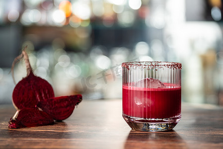 混合酒精饮料摄影照片_木桌上优雅玻璃杯中的酒精甜菜根鸡尾酒饮料。