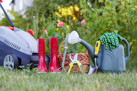 带橡胶靴的电动割草机、草地上的园艺工具