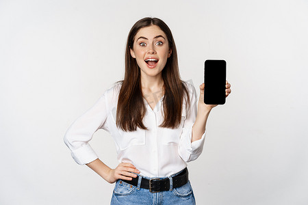 app展示摄影照片_微笑的女人展示智能手机应用程序界面、手机屏幕、展示促销优惠、站在白色背景上