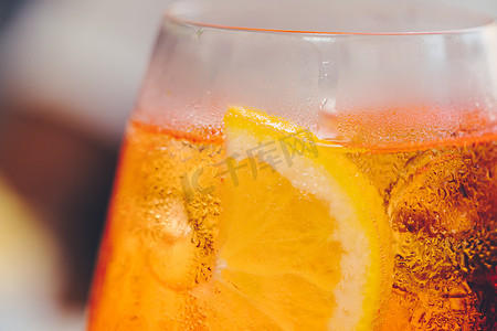 一杯冰镇阿佩罗雪碧鸡尾酒装在酒杯中，装饰着橙片。