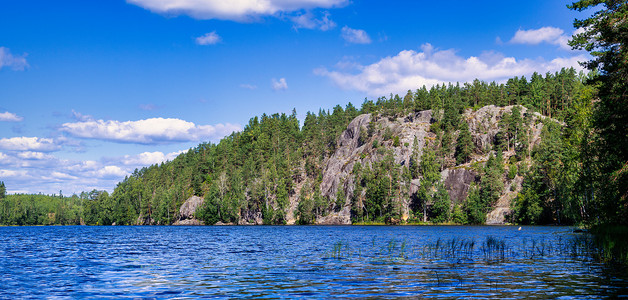 森林湖 Yastrebinoye 的风景有冰河时代岩石的在背景中。