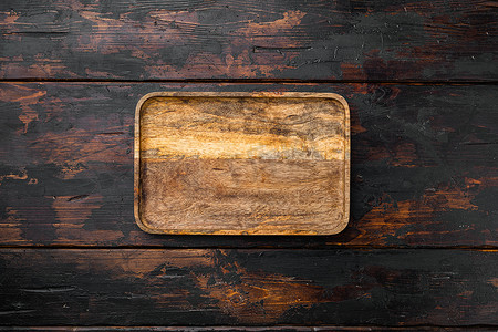质朴的食物切板，顶视图平躺，带有文本或产品的复制空间，位于旧的深色木桌背景上