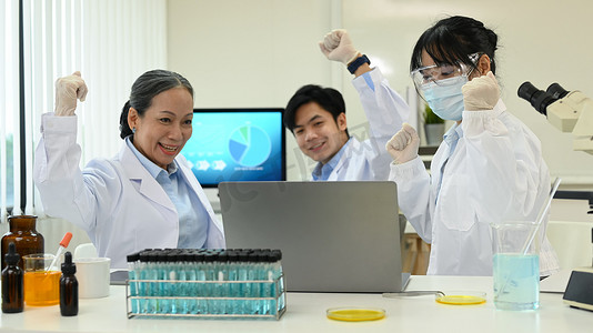 一群快乐的科学家庆祝实验的成功结果，在研究实验室取得了重要发现