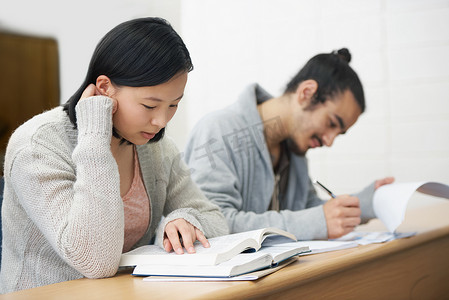 这项测试可能会改变他们的生活，使他们的生活变得更糟或更好……两名学生坐在报告厅里准备考试的图片。