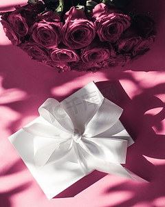粉色浪漫玫瑰花束摄影照片_豪华假日丝绸礼盒和粉色背景玫瑰花束、浪漫惊喜和鲜花作为生日或情人节礼物
