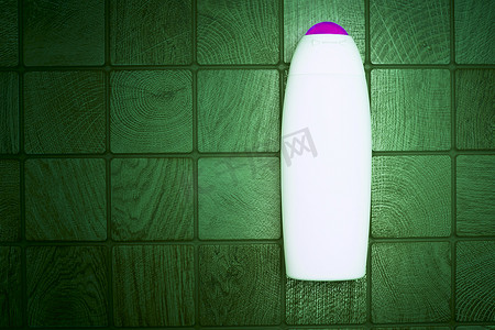 一个用于洗涤剂的塑料瓶以深绿方块为背景