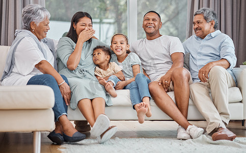 家庭预算表摄影照片_快乐而深情的年轻混血家庭六口人坐在家里客厅的沙发上。