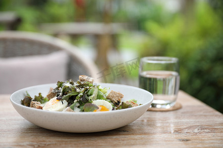 凯撒沙拉摄影照片_木质背景上的凯撒沙拉开胃菜