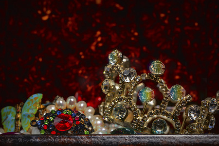 红色背景皇冠摄影照片_红色背景上的珠宝首饰和皇冠的一部分。