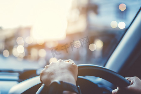 方向盘上的女人的手驾驶汽车背景。