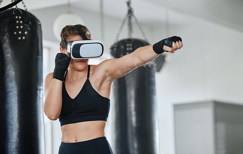 健康、健康、活跃的拳击女性戴着 VR 耳机，可以在健身房锻炼、训练和锻炼时访问虚拟世界。