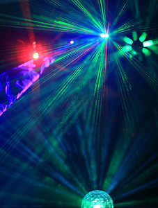 disco舞厅摄影照片_用明亮的探照灯光束照明迪斯科舞厅，激光表演。