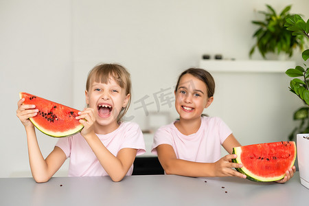两个孩子吃一片西瓜。